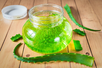 Aloe Vera gel on a wooden background. Natural gel and aloe leaves close up.