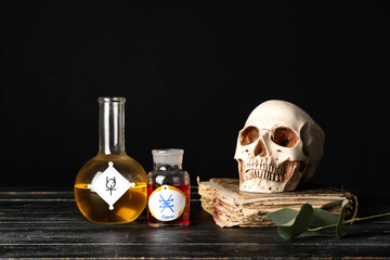 Potions, human skull and old book on alchemist's table