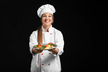 Young female chef with tasty dish on dark background