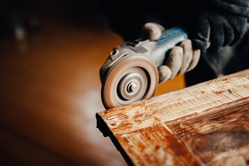 woodwork, a grinder cuts old paint and varnish from a solid wood board. furniture restoration.