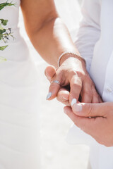 Newlyweds at the wedding romantic couple holding hands during destination wedding marriage matrimonial ceremony on the sandy beach in Dominican republic, Punta Cana. Family, love, unity concept.  
