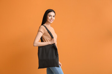 Young woman with eco bag on color background