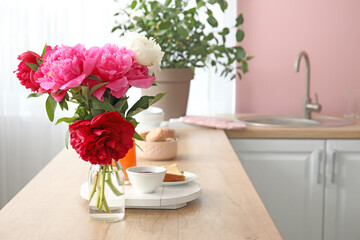 Bouquet of flowers on table in modern kitchen