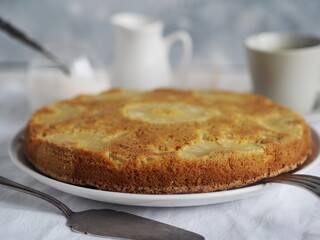 Pastry background. Close up.Round sponge cake with pineapple on a white wooden table. Healthy natural food.