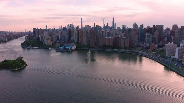 Aerial footage lands looking ahead to Manhattan, NYC over the water.  Traffic on FDR drive.  in 4K.