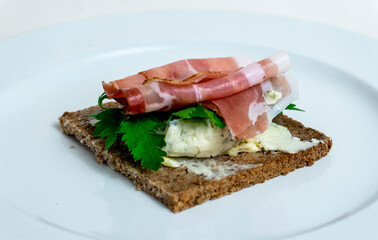 sandwich with ham, cheese and parsley on black bread