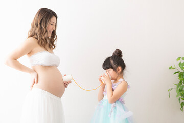 Fototapeta na wymiar ドレスを着た妊婦さんと女の子のポートレート