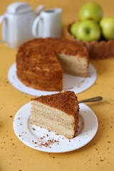 slice of honey cake on yellow background with green apples 