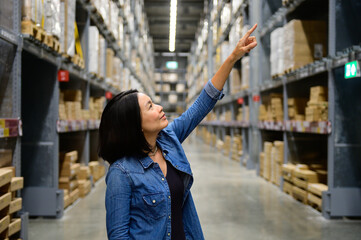 Portrait of female manager looking at shipping box and pointing order