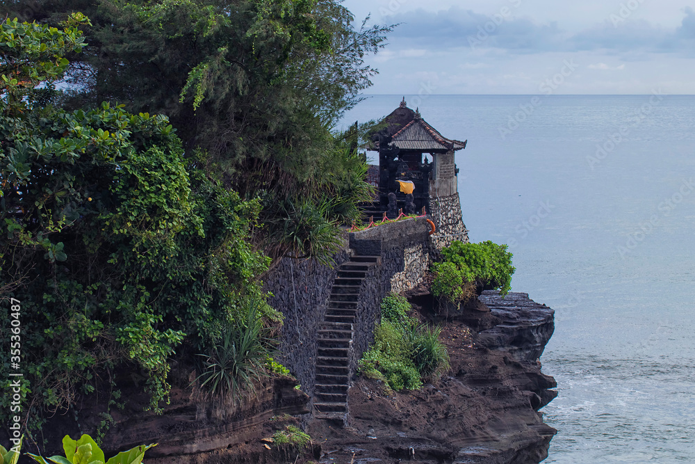 Poster Unique architectural of a temple with a staircase by the cliff in Tanah Lot, Bali