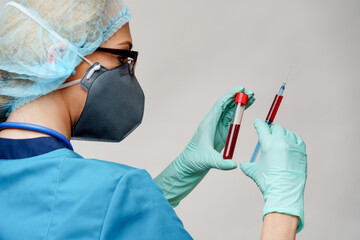 medical doctor nurse woman wearing protective mask and gloves - holding virus blood test tube and...