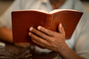 Fototapeta premium African American man praying and reading the Bible.