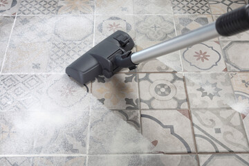 Vacuum cleaner on porcelain stoneware floor with copyspace