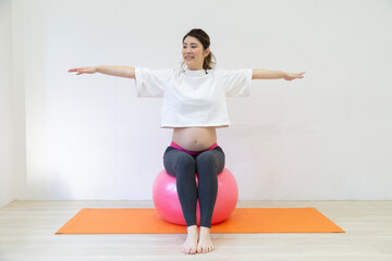 Fototapeta premium バランスボールに座る妊婦さん