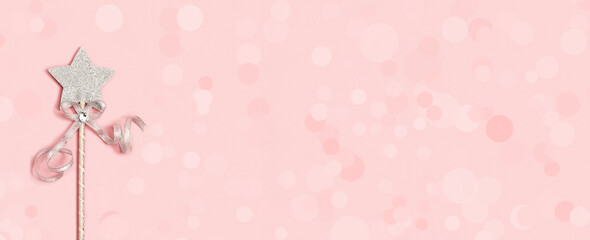 Festive decoration, magic wand, bright silver star with shine on soft pink background with copy...