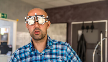 vision measurement by optometrist at clinic, young man as patient