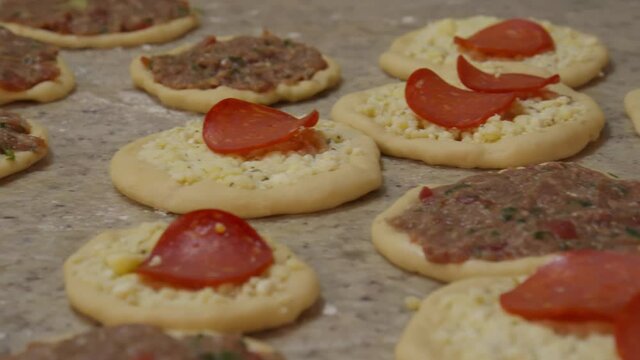 Raw pizza-like bread with ground beef and pepperoni and cheese toppings - Raw esfiha