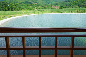 View from wooden balcony terrace of natural lake landscape with green mountain range