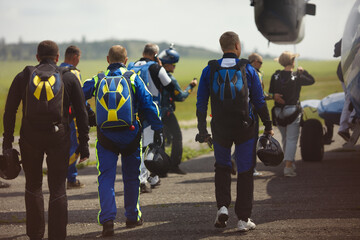 Team of skydivers heading to the plane during a skydiving competition.