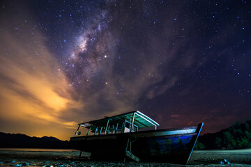 Amazing beautiful of night sky Milky Way Galaxy with abandon fisherman boat