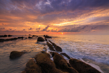 Amazing twilight Sunset seascape with sea wave hitting the green moss