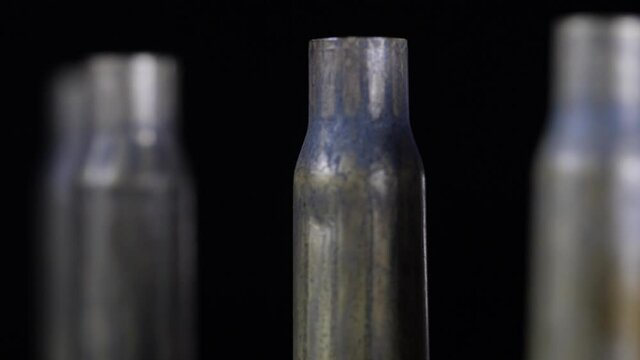 Close-up rotating shot of bullet shells standing all in a row.