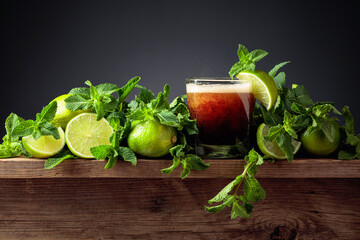 Carbonated drink with limes and mint on a old wooden table.