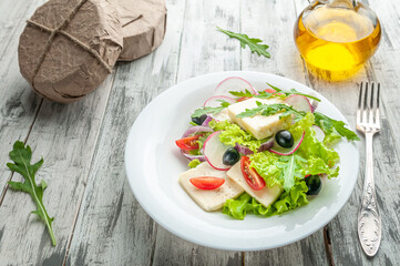 Salad with Adyghe cheese, arugula, olives, radishes, red onions and cherry tomatoes.