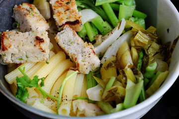 vegetarian Penne pasta soup bowl with vegetables, vegan food from macaroni with kale, tofu pie