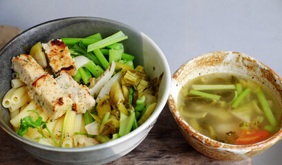 vegetarian Penne pasta soup bowl with vegetables, vegan food from macaroni with kale, tofu pie