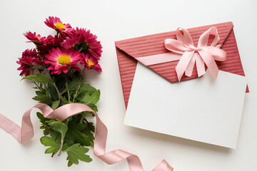 greeting card design. burgundy chrysanthemums and an envelope on a white background. congratulation. invitation. place for text. flat lay. view from above