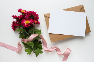 greeting card design. burgundy chrysanthemums and an envelope on a white background. congratulation. invitation. place for text. flat lay. view from above