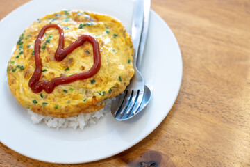 
Omelette on a white plate with red heart-shaped sauce