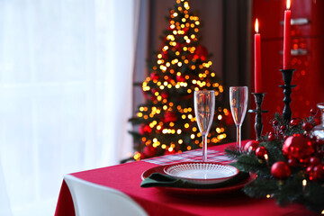 Table served for festive dinner and Christmas tree in stylish kitchen interior