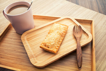 Hot coffee and pies on a wooden tray