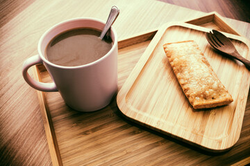 Hot coffee and pies on a wooden tray