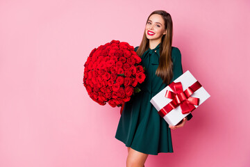 Photo of adorable chic lady hold large red long roses bouquet big gift box overjoyed boyfriend husband birthday surprise wear green mini dress isolated pastel pink color background