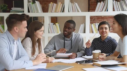 Happy multiethnic diverse college university students team study together prepare for exam in library, multicultural young people group talk laugh help do research project brainstorm in cooperation - Powered by Adobe