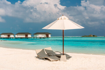 Chaise-longues on the island beach of Maldives.