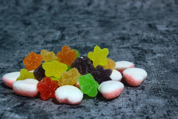 colorful candy with a variety of flavors in the photo with a cement-patterned background, the color of bright candy and fresh flavors arouse children's tastes,