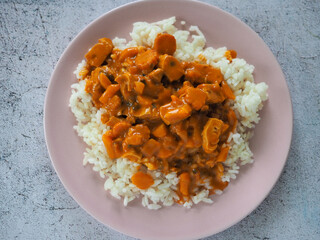 Rice with vegetarian red curry on grey rustic background.
