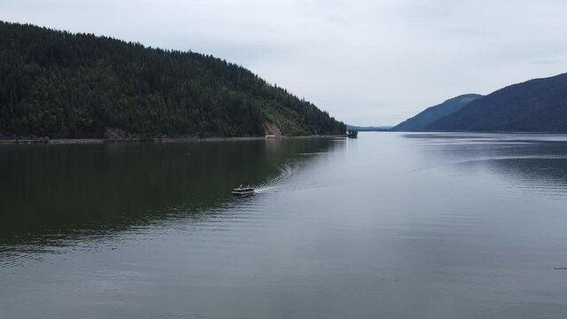 A drone following a pontoon boat on the Shuswap lake in Canada.