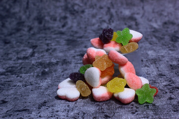 colorful candy with a variety of flavors in the photo with a cement-patterned background, the color...