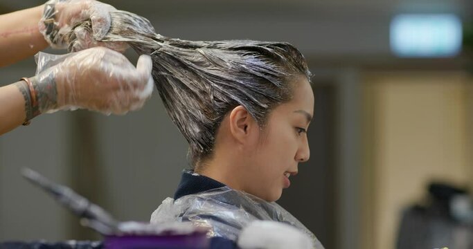 Woman dye her hair at beauty salon