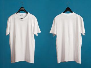 Exclusive hanger with empty white t-shirt hanging isolated on a blue background. Blank white male tshirt template, from two sides,  for your mockup design to be printed.