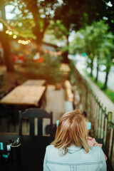 Young woman waiting for drink and food in sidewalk cafe