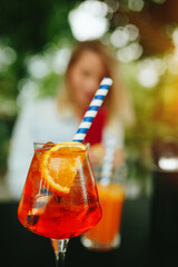 Glass of Aperol Spritz and blue straw, Italian Cocktail