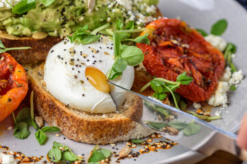 Avocado Toast featuring smashed avocado, grilled tomatoes, boiled egg on sourdough toast