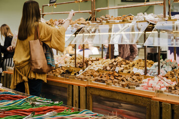 Woman buying candy, sweets in shop. Retail. Space for text.