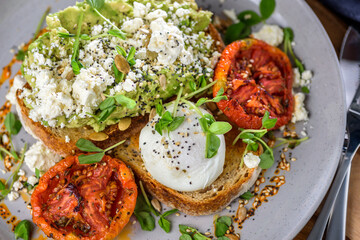 Avocado Toast featuring smashed avocado, grilled tomatoes, boiled egg on sourdough toast